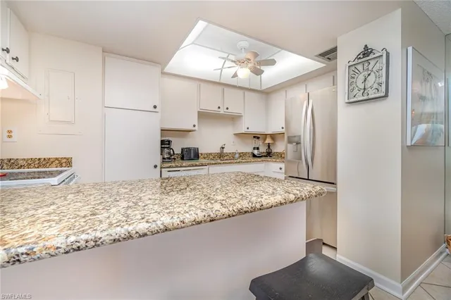 a kitchen with stainless steel appliances granite countertop a sink refrigerator and cabinets