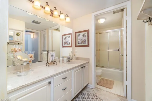 a bathroom with double vanity sink a mirror and a shower