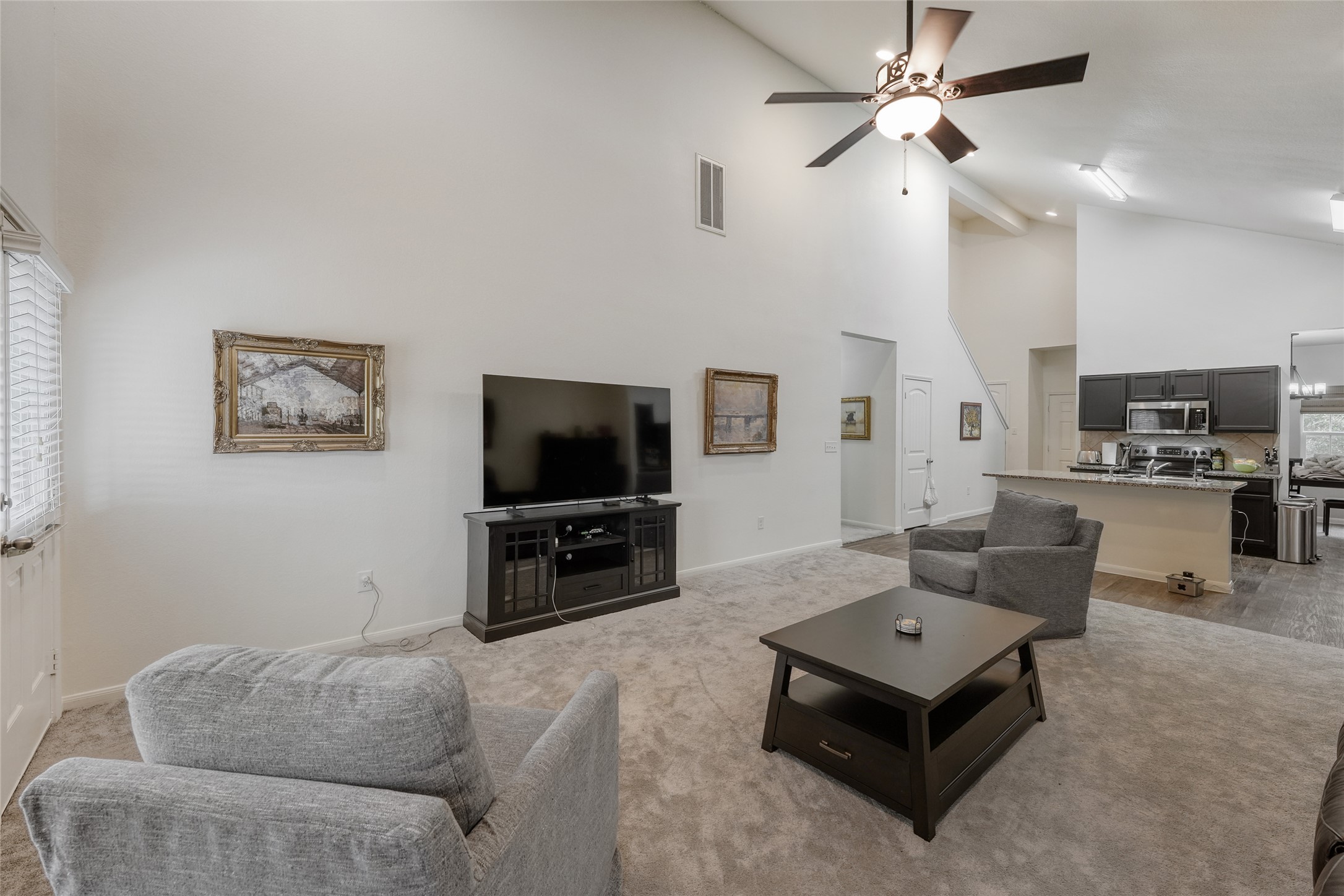 15105 Shell Bark Cove Austin, TX 78724 - Photo 15 of 30 A well-lit great room, featuring soaring ceilings and an open-concept kitchen with abundant storage.