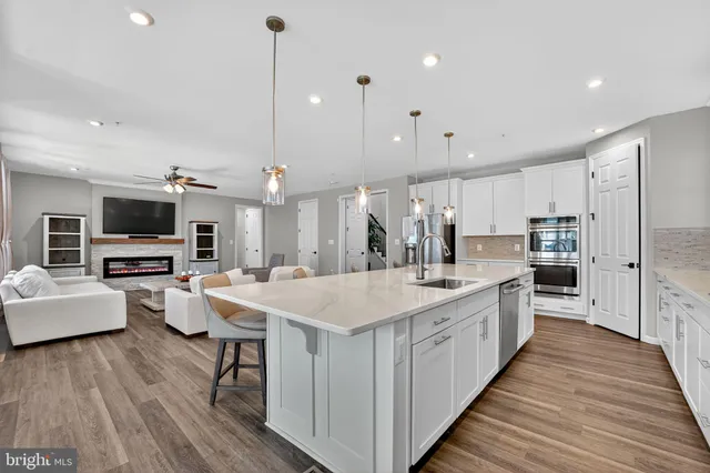 a large kitchen with stainless steel appliances kitchen island granite countertop a large island in the center
