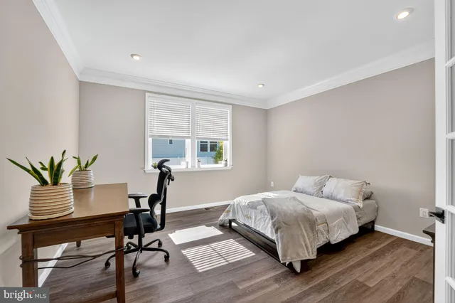 a bedroom with a bed table and a window
