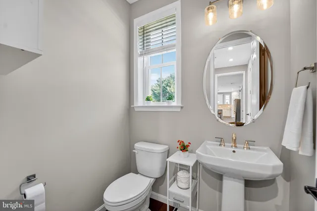 a bathroom with a toilet a sink and mirror