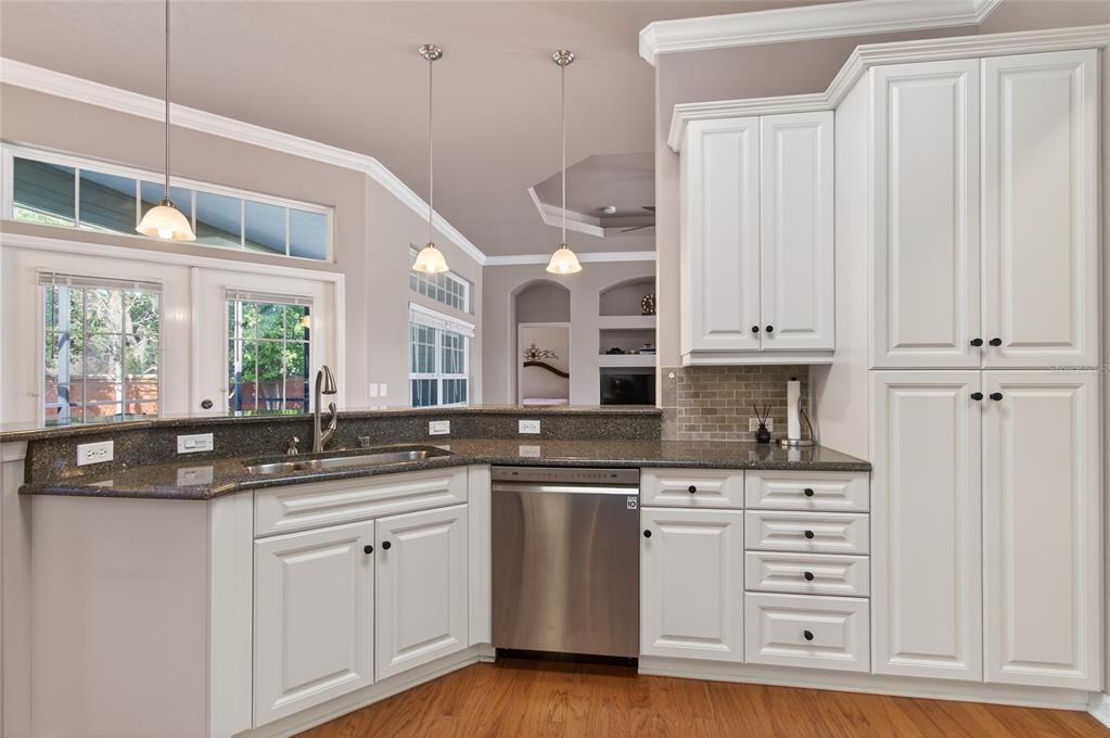 3762 Southwest 74th Drive Gainesville, FL 32608 - Photo 24 of 37 a kitchen with stainless steel appliances granite countertop a sink and cabinets with wooden floor