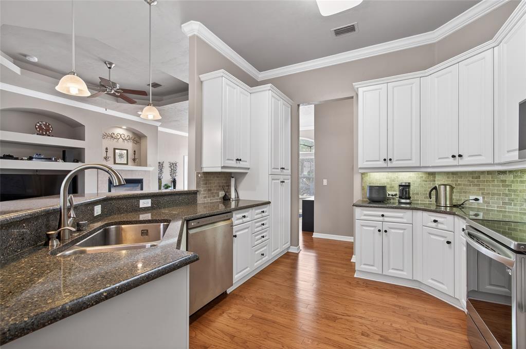 3762 Southwest 74th Drive Gainesville, FL 32608 - Photo 7 of 37 a kitchen with stainless steel appliances granite countertop a sink stove and cabinets