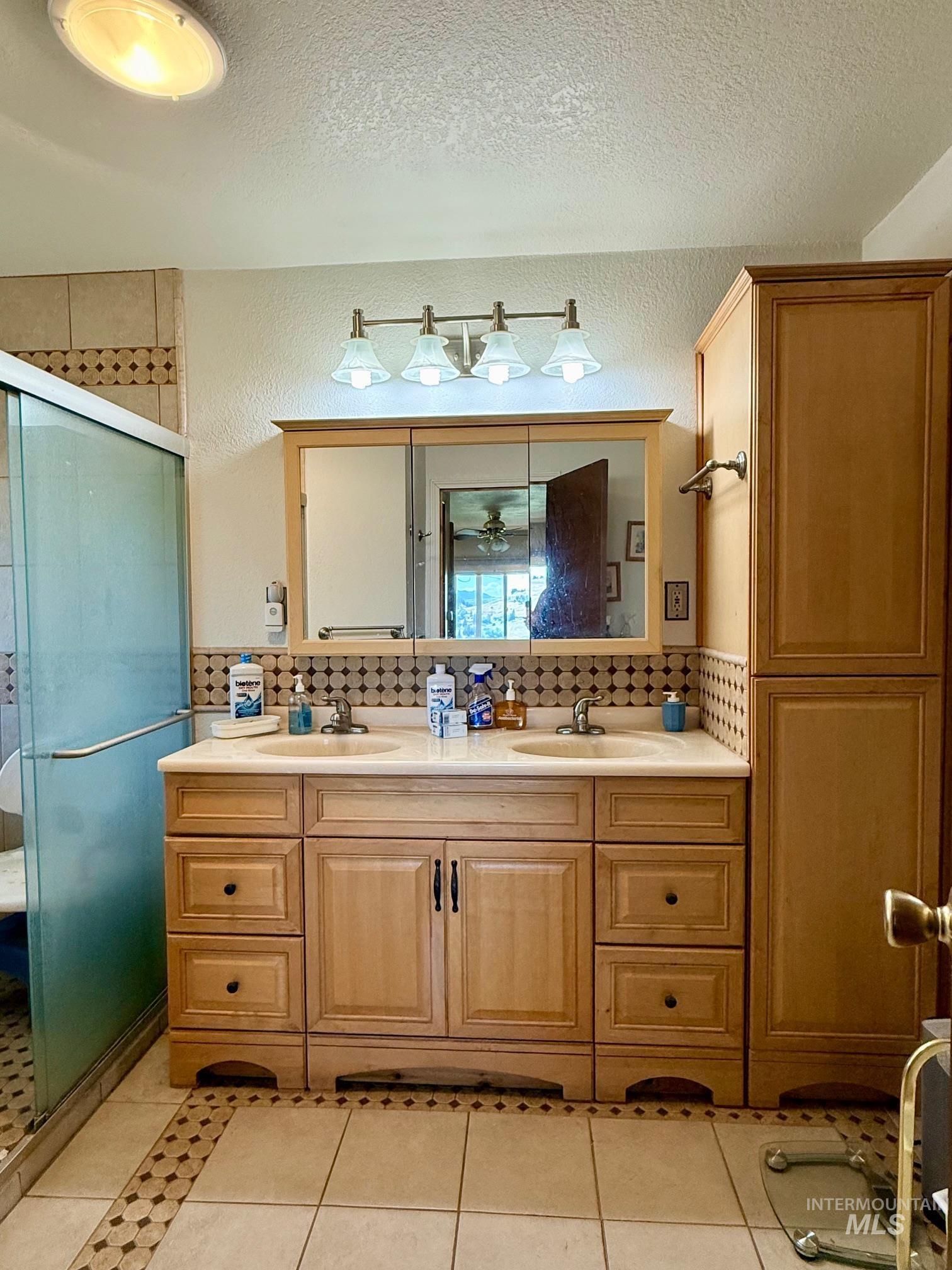 35322 River Road Lenore, ID 83541 - Photo 18 of 42 Double vanity with integrated sinks, light wood cabinetry, and a countertop