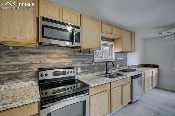 a kitchen with stainless steel appliances granite countertop a sink stove and microwave