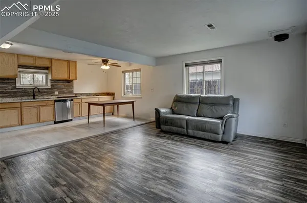 a living room with furniture and a wooden floor