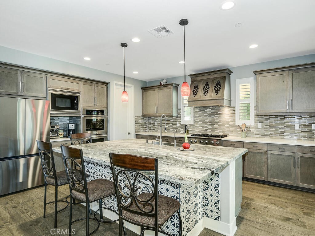 374 Ventasso Way Fallbrook, CA 92028 - Photo 7 of 42 a kitchen with stainless steel appliances granite countertop a stove top oven a sink refrigerator and a view of living room