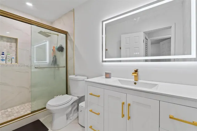 a bathroom with a sink a toilet and shower