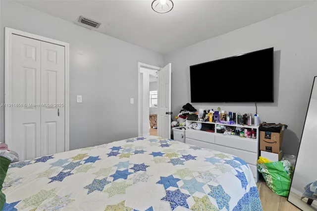 a bedroom with a bed and a flat screen tv
