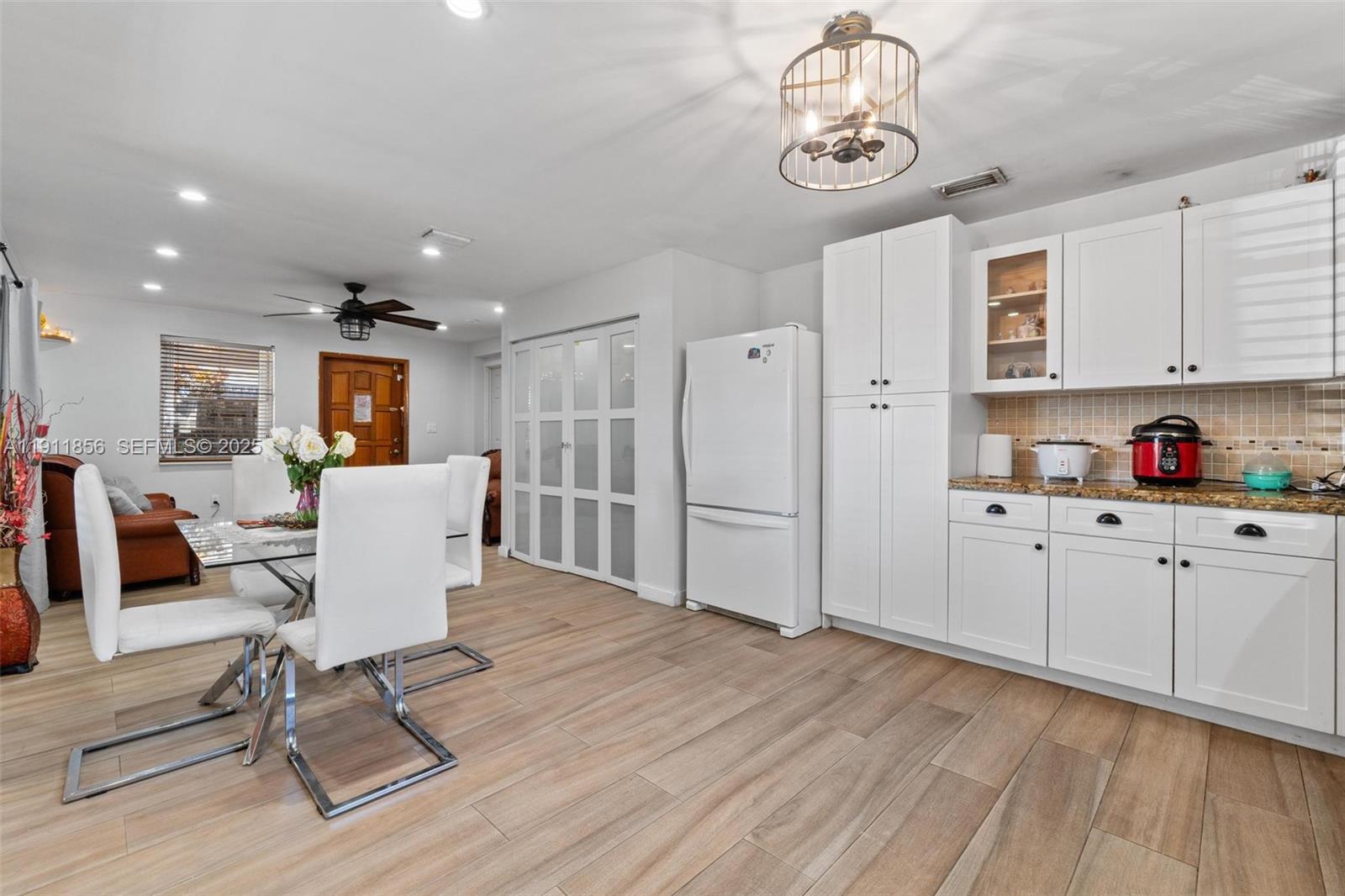 580 East 44th Street Hialeah, FL 33013 - Photo 19 of 41 a view of kitchen center island wooden floor cabinets and living room view