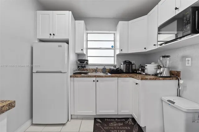 a kitchen with stainless steel appliances a refrigerator a sink and cabinets