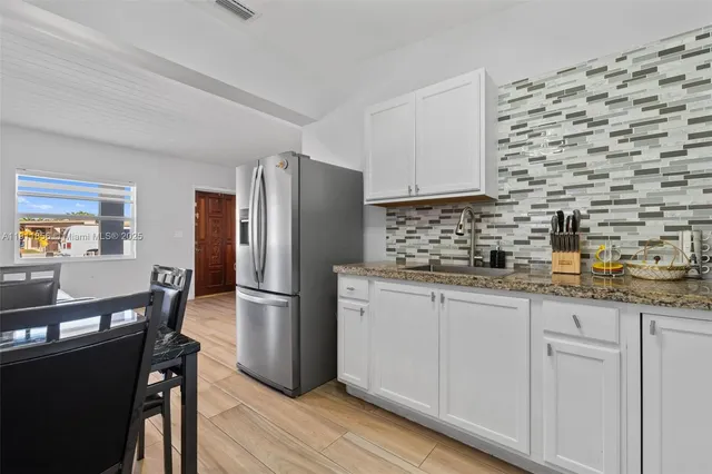 a kitchen with stainless steel appliances a refrigerator sink and cabinets