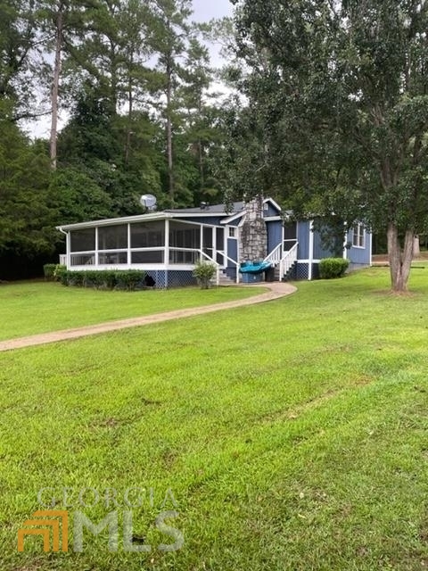 558 Jackson Lake Inn Road Jackson, GA 30233 - Photo 1 of 1 a view of a house with a big yard and large trees