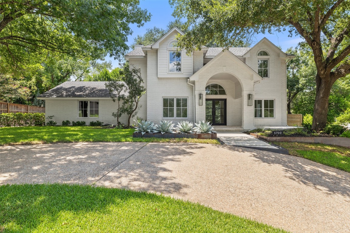 5700 Carry Back Lane Austin, TX 78746 - Photo 11 of 40 a front view of a house with a garden and trees
