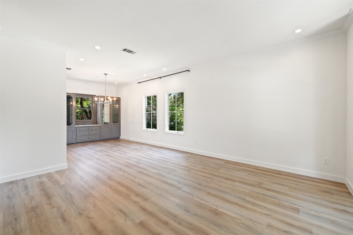 5700 Carry Back Lane Austin, TX 78746 - Photo 15 of 40 an empty room with wooden floor and windows