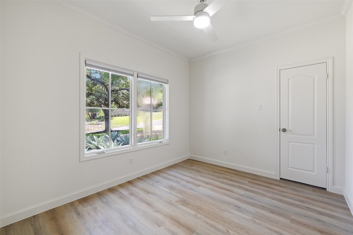 5700 Carry Back Lane Austin, TX 78746 - Photo 25 of 40 an empty room with wooden floor and windows