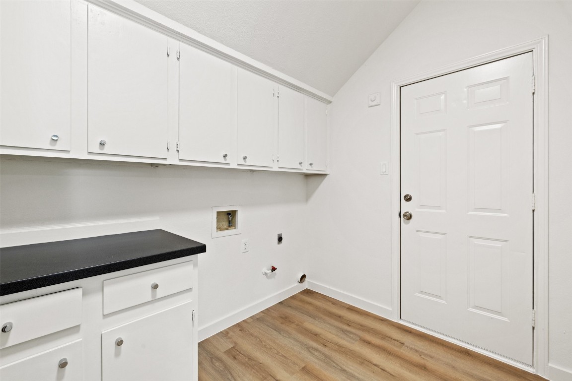 5700 Carry Back Lane Austin, TX 78746 - Photo 29 of 40 a view of a kitchen with white cabinets and a wooden floor