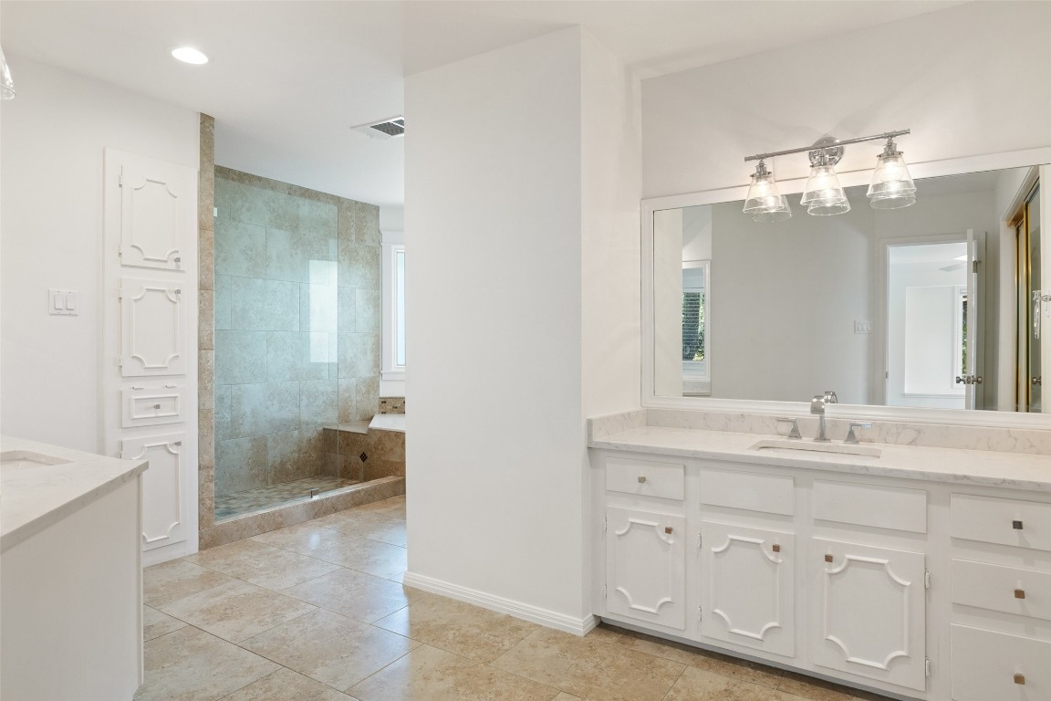 5700 Carry Back Lane Austin, TX 78746 - Photo 32 of 40 a spacious bathroom with a granite countertop sink mirror and a