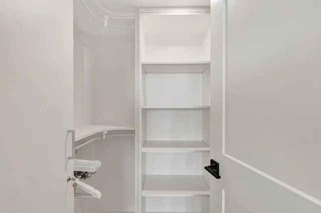 a view of walk in closet with empty racks