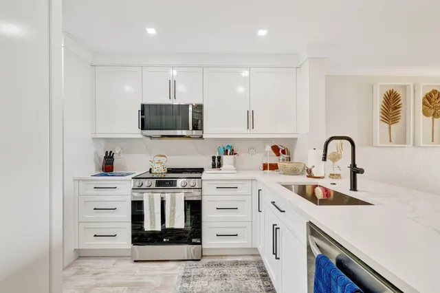 a kitchen with stainless steel appliances granite countertop a stove top oven a sink and dishwasher