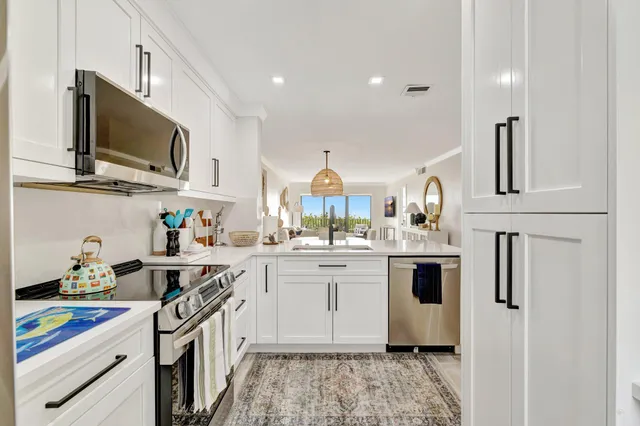 a kitchen with stainless steel appliances granite countertop a sink and a stove