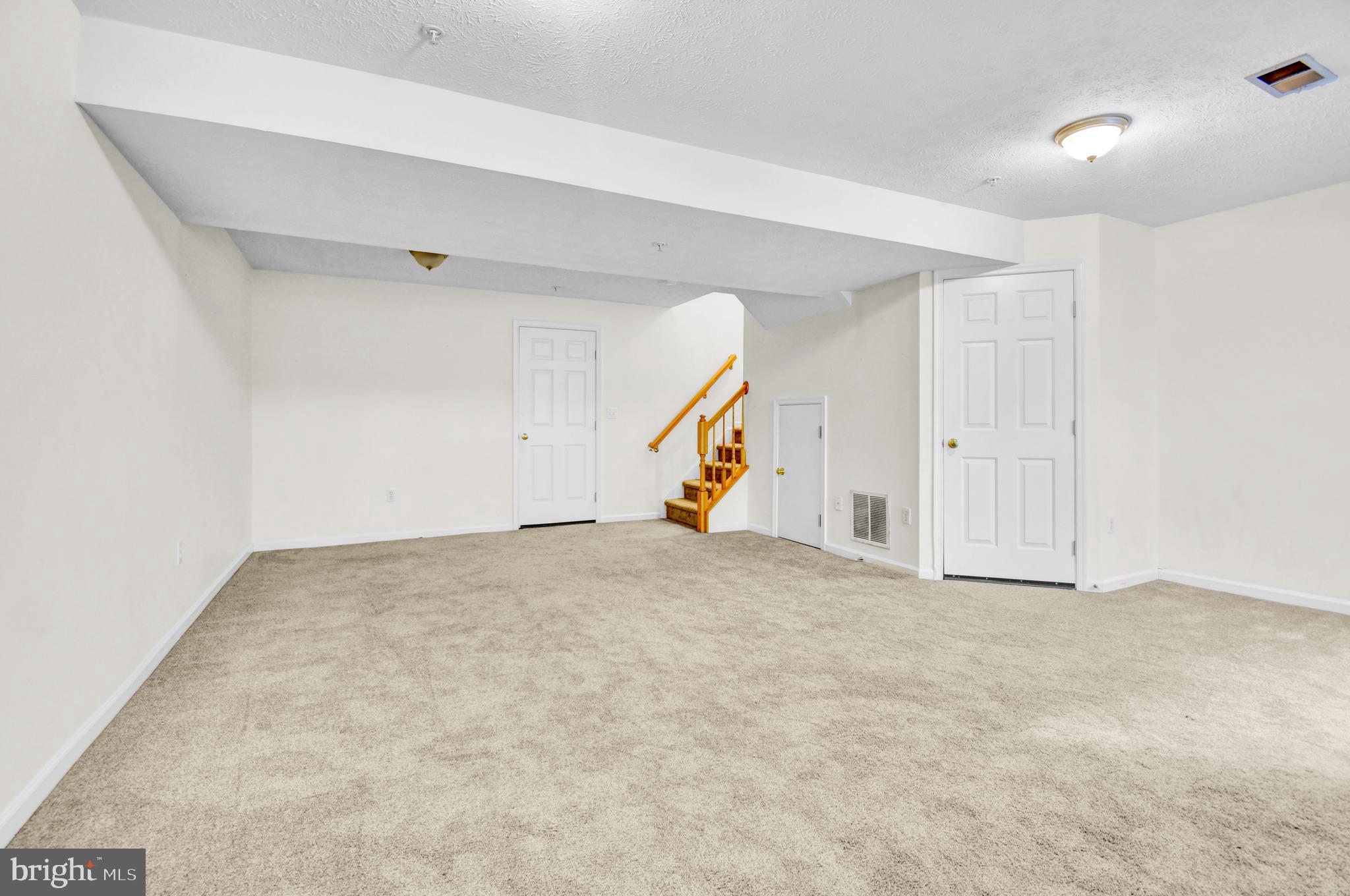 8036 Silver Fox Way Chesapeake Beach, MD 20732 - Photo 19 of 22 an empty room with an entryway and stairs