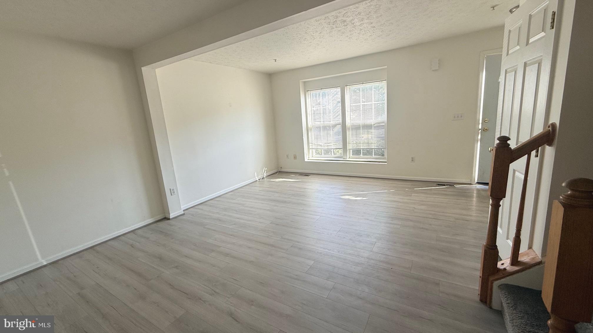 8036 Silver Fox Way Chesapeake Beach, MD 20732 - Photo 2 of 19 an empty room with wooden floor and windows