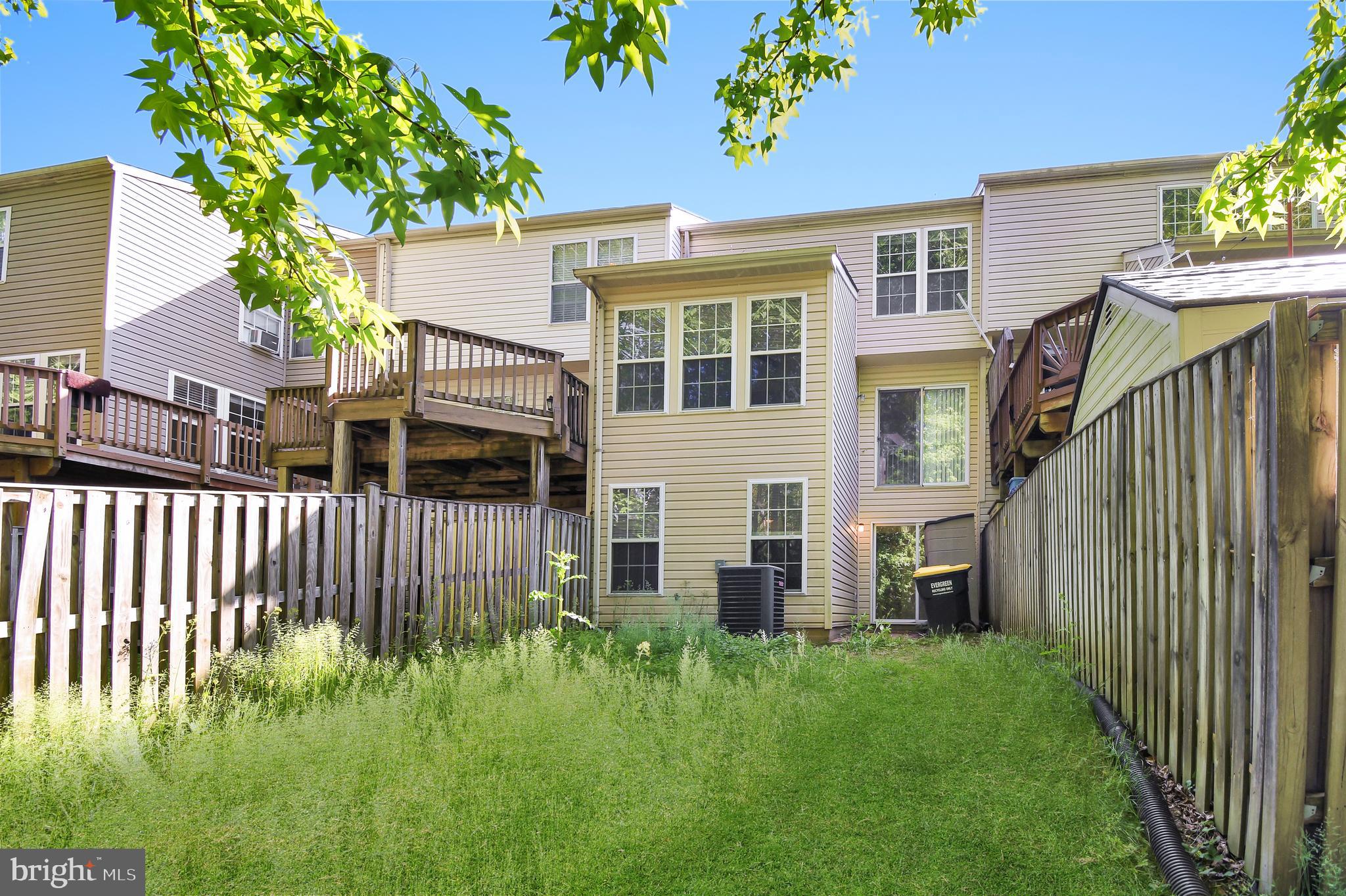 8036 Silver Fox Way Chesapeake Beach, MD 20732 - Photo 21 of 22 a view of a house with brick walls and a flower garden with wooden fence