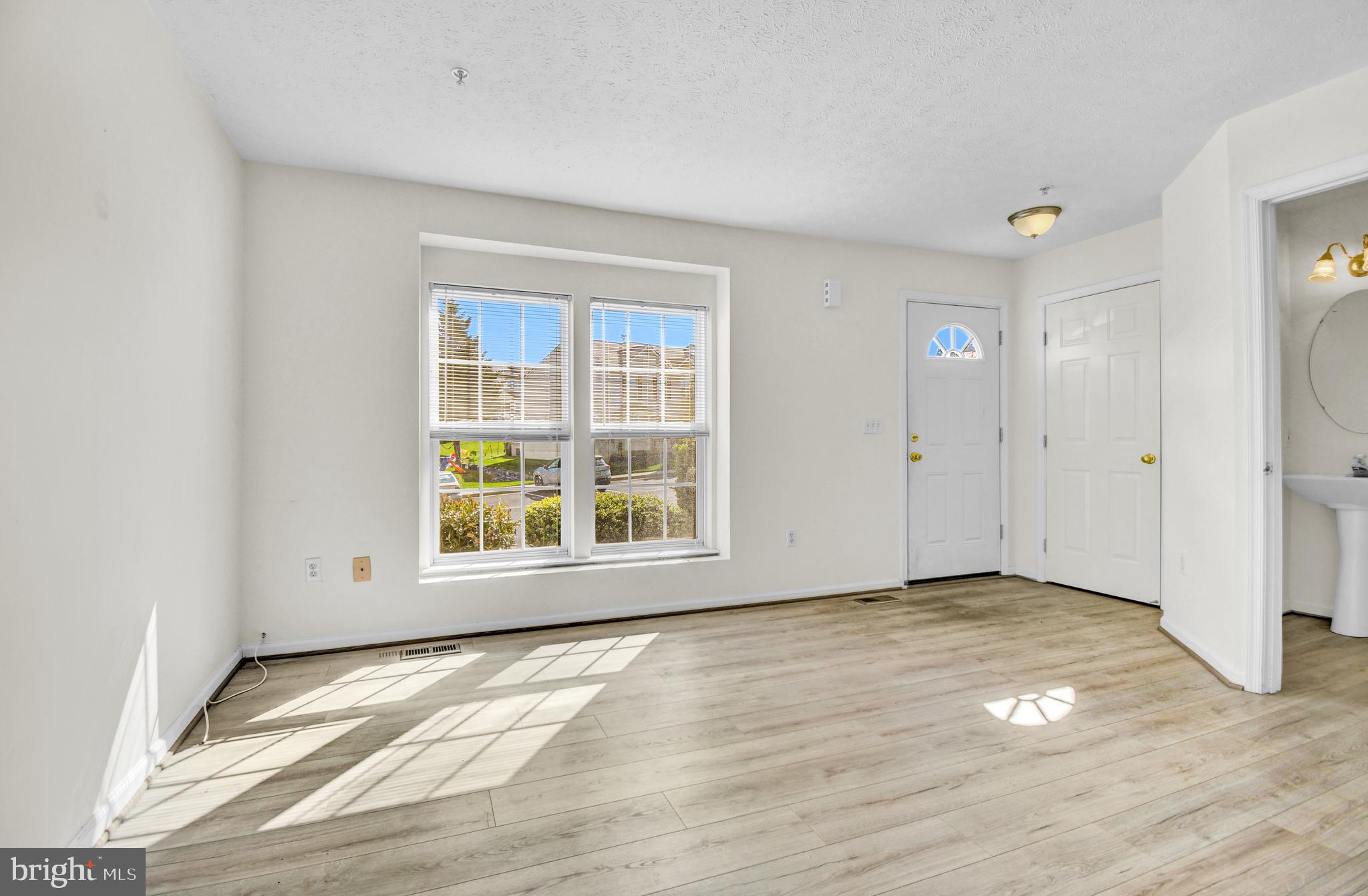 8036 Silver Fox Way Chesapeake Beach, MD 20732 - Photo 3 of 22 a view of an empty room with wooden floor and a window