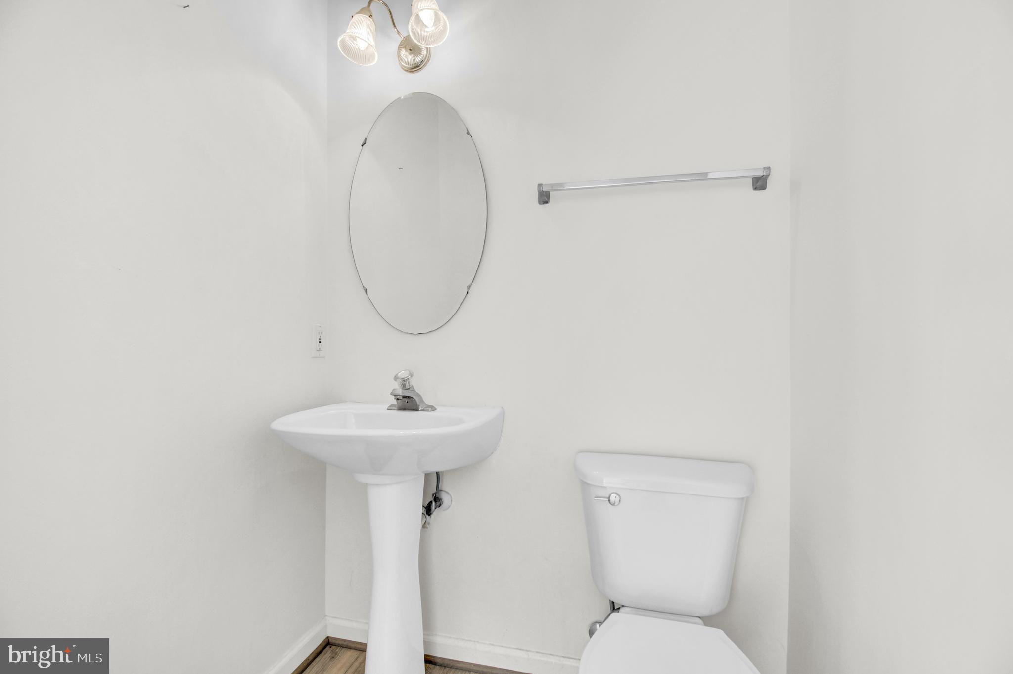 8036 Silver Fox Way Chesapeake Beach, MD 20732 - Photo 4 of 22 a bathroom with a toilet a sink and a mirror
