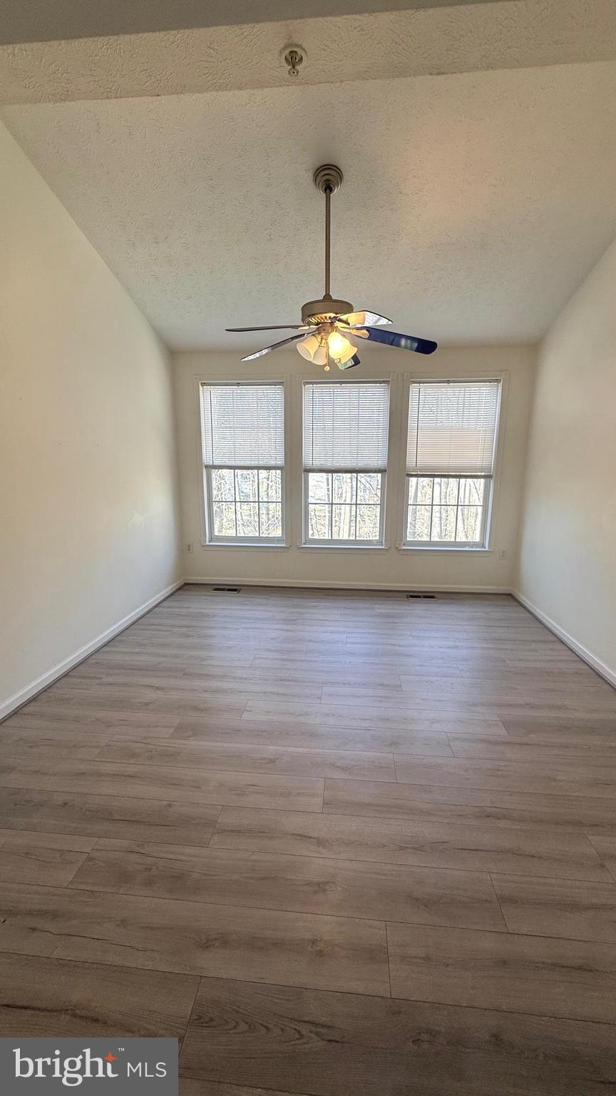 8036 Silver Fox Way Chesapeake Beach, MD 20732 - Photo 7 of 19 a view of an empty room with window and wooden floor