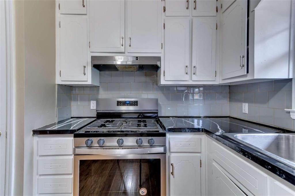 3959 Emerald Springs Court Decatur, GA 30035 - Photo 8 of 27 a kitchen with granite countertop white cabinets and stainless steel appliances