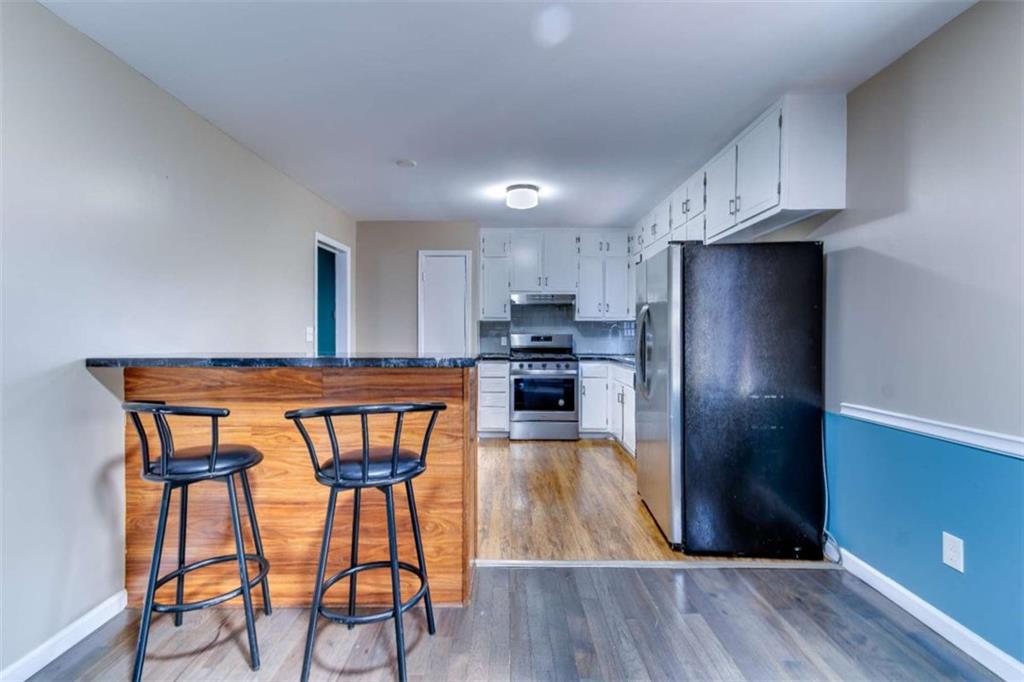 3959 Emerald Springs Court Decatur, GA 30035 - Photo 9 of 27 a kitchen with stainless steel appliances a dining table chairs refrigerator and sink