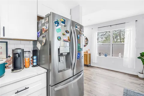 a view of a kitchen with fridge and front door
