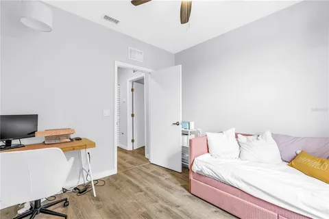 a bedroom with a bed and wooden floor