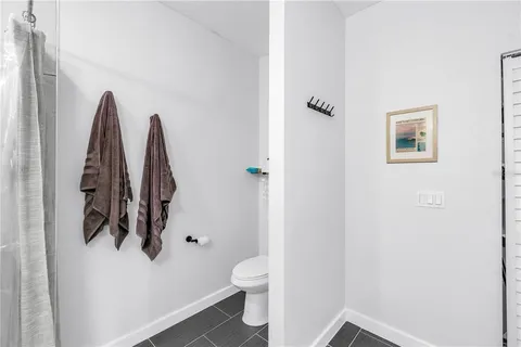 a bathroom with a toilet and a view of a bathroom