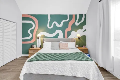 a bedroom with a bed and painting on the wall