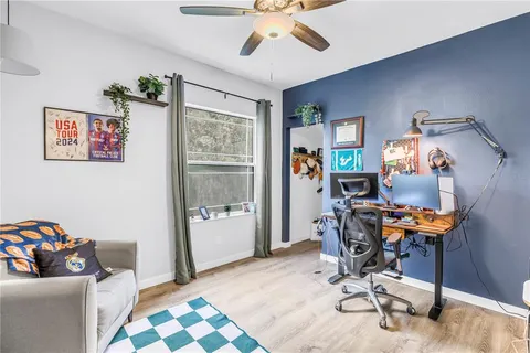 a view of a workspace with furniture and a window