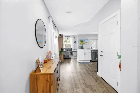a living room with furniture a mirror and a wooden floor