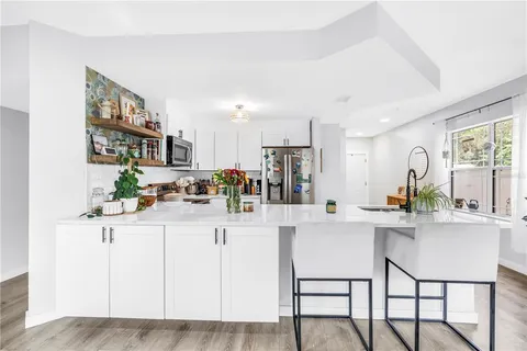 a kitchen with stainless steel appliances a table and chairs