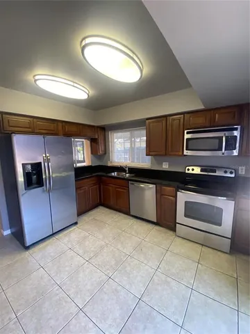 a kitchen with stainless steel appliances granite countertop a stove a sink and a microwave