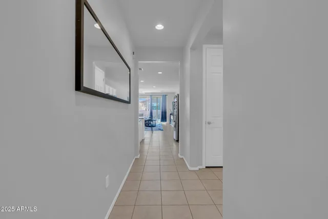 a living room with stainless steel appliances a table and chairs in it