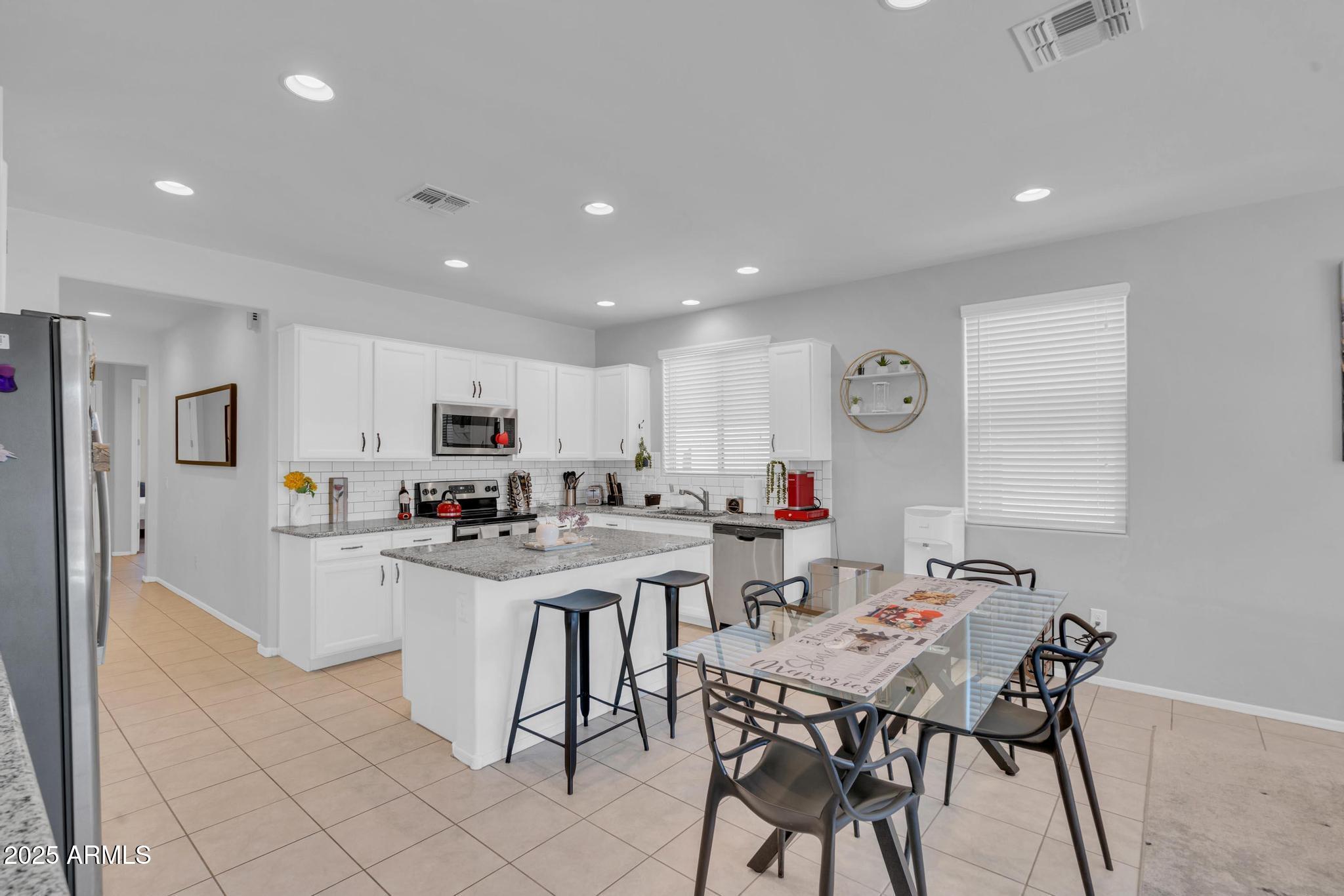 6556 East Via Arroyo Azul Tucson, AZ 85756 - Photo 21 of 75 a living room with stainless steel appliances a table and chairs in it