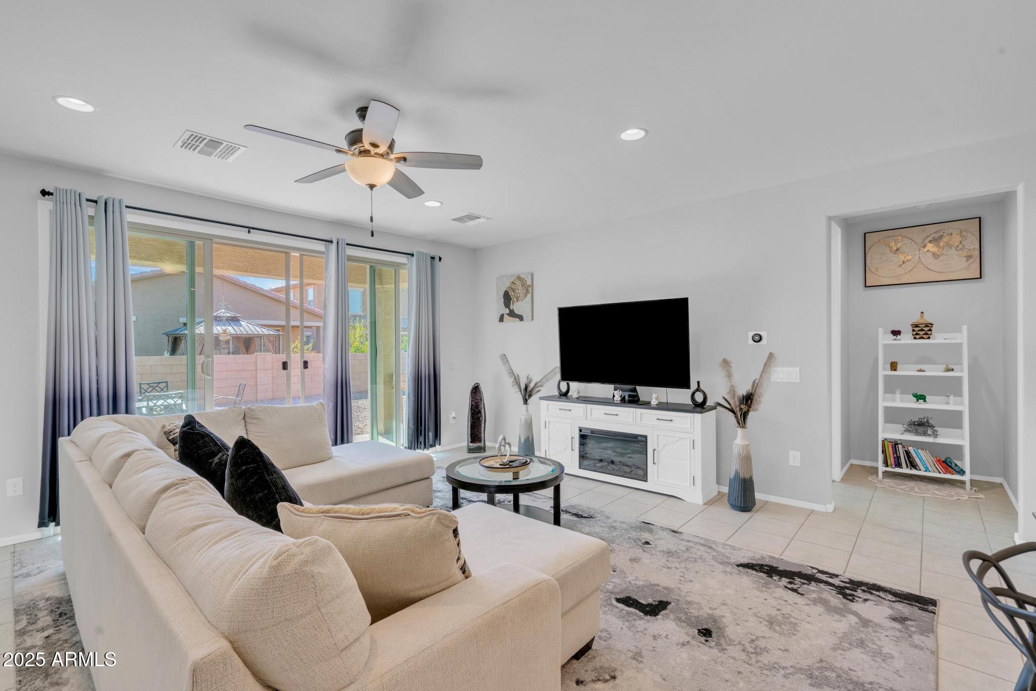 6556 East Via Arroyo Azul Tucson, AZ 85756 - Photo 26 of 75 a living room with furniture a flat screen tv and a fireplace