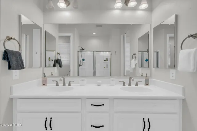 a en suite bathroom with a double vanity sink and a mirror