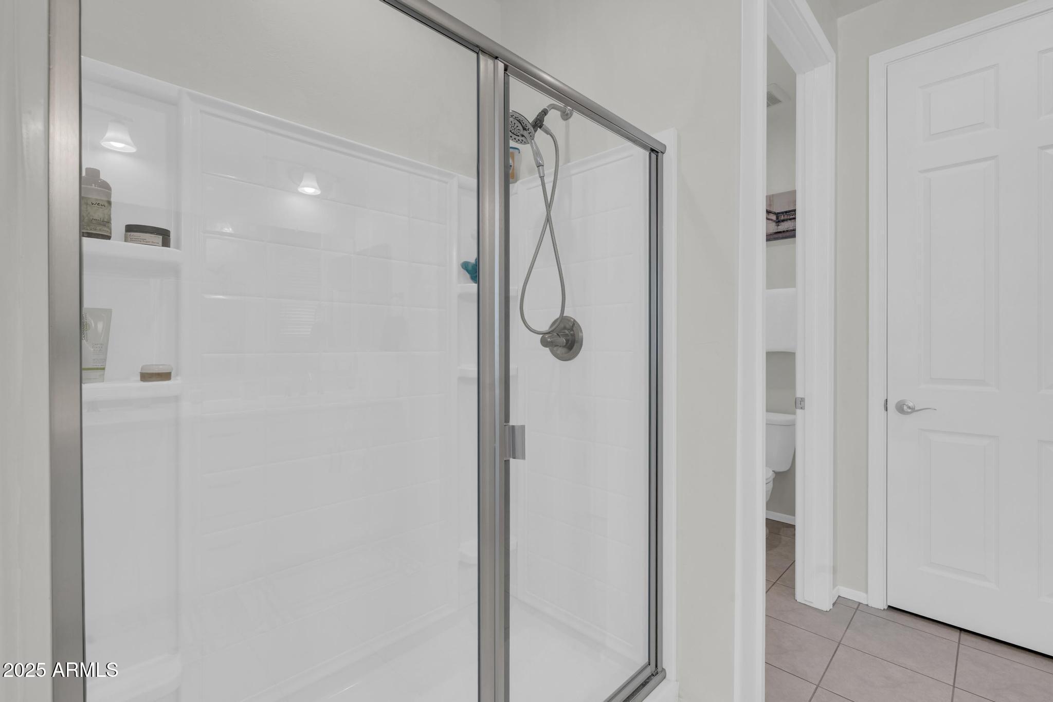 6556 East Via Arroyo Azul Tucson, AZ 85756 - Photo 33 of 75 a bathroom with a glass shower door