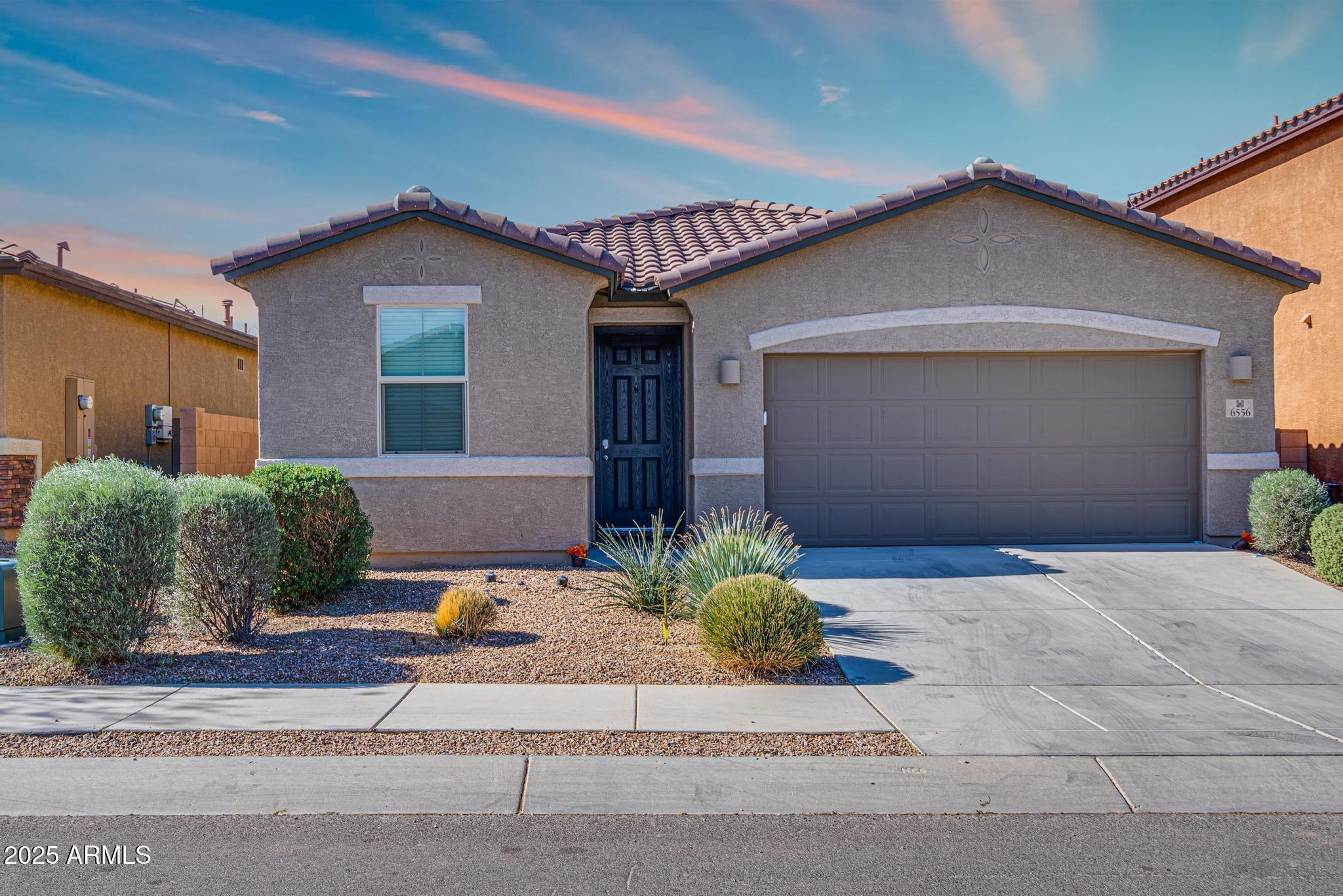 6556 East Via Arroyo Azul Tucson, AZ 85756 - Photo 39 of 75 a front view of a house with a yard and garage