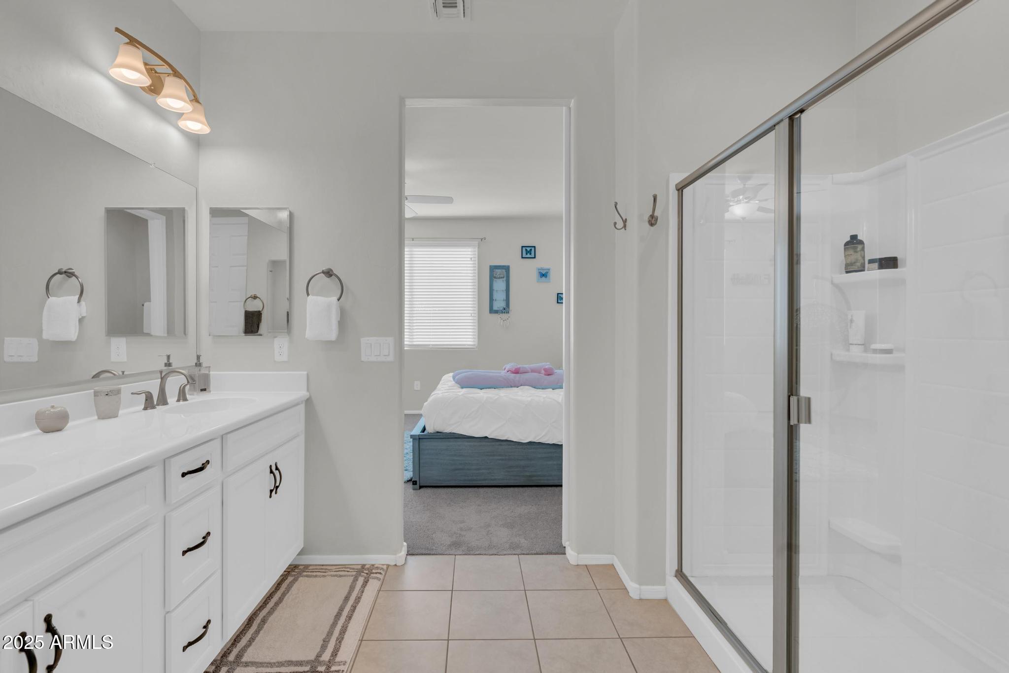 6556 East Via Arroyo Azul Tucson, AZ 85756 - Photo 45 of 75 a en suite bathroom with a double vanity sink and a mirror