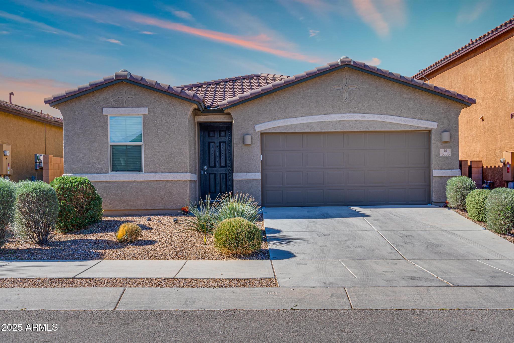 6556 East Via Arroyo Azul Tucson, AZ 85756 - Photo 4 of 75 a front view of a house with a yard and garage